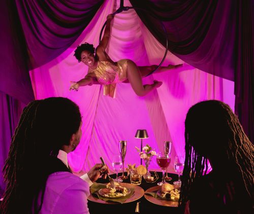 Aerial performer over candlelit tables